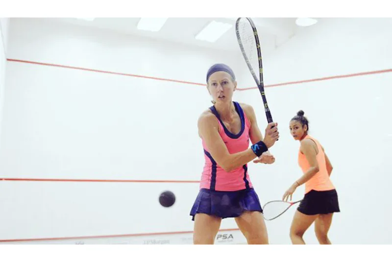 Pilates for Squash Players - Two females playing squash in a squash court