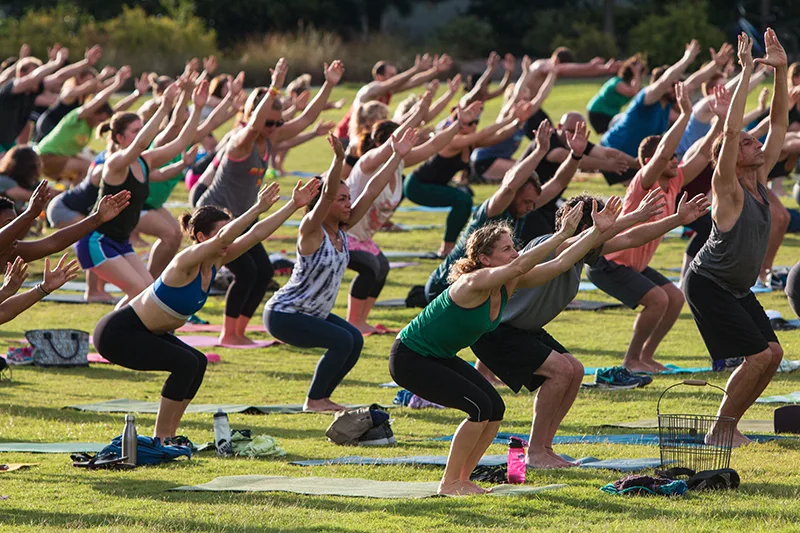 People Do Utkatasana Pose In Outdoor Group Yoga Class