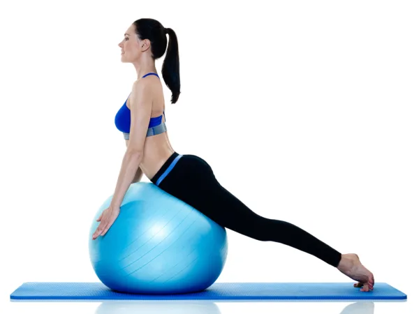 Pilates exercise balls - A female exercising using a pilates exercise ball