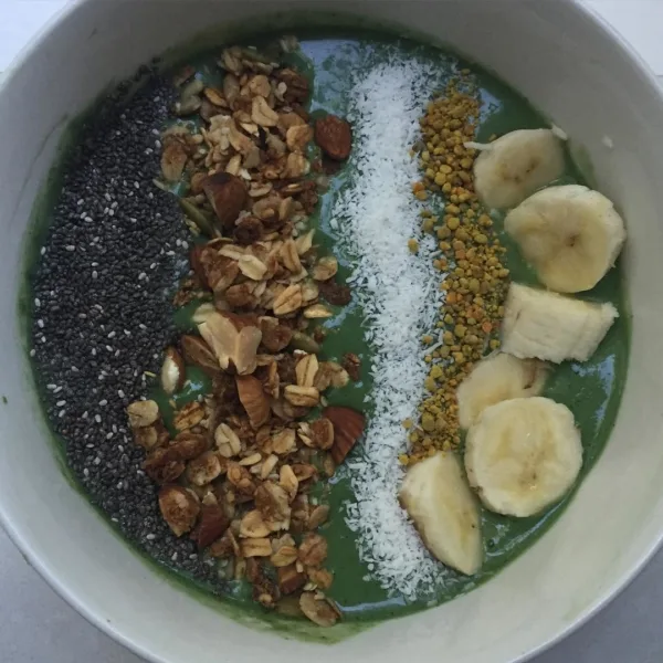 A pilates instructor - A bowl of fruit and nuts arranged in rows on green yoghurt