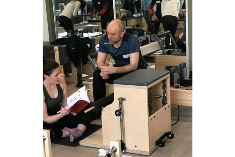 Pilates teachers - A male and female Pilates teachers in training discussing options in a studio