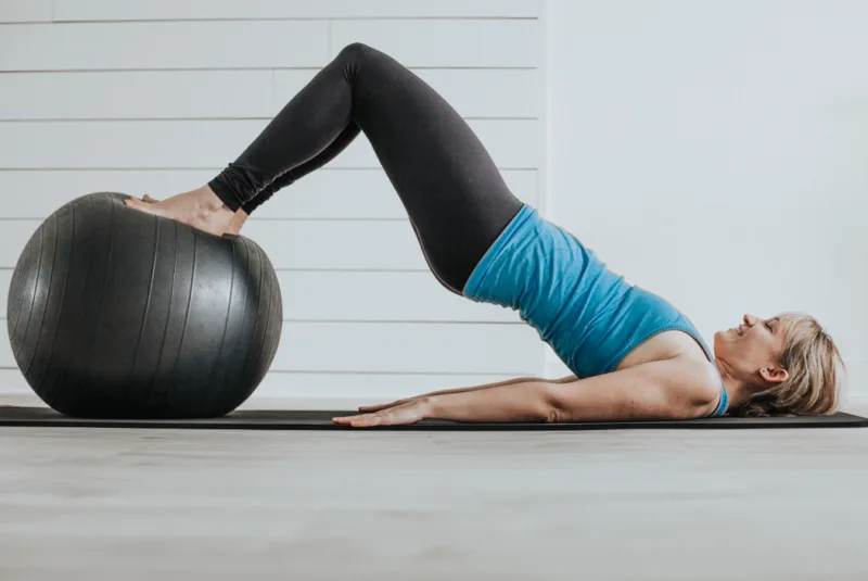 Tight hamstrings - A female performing the bridge using a ball