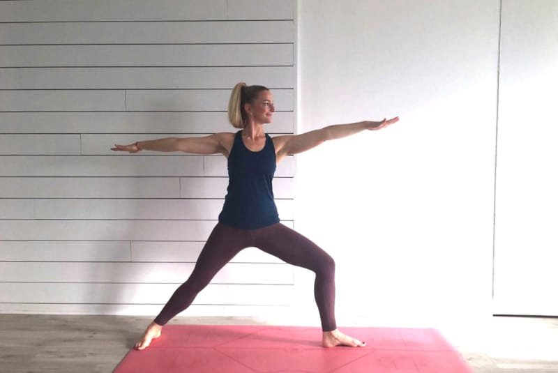 Yoga advantages - A woman performing Yoga on a red mat in a studio