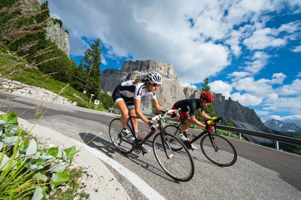 Man and woman on racing bikes on a mountain road-min