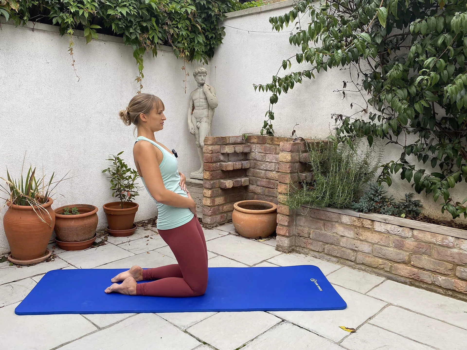 Instructor doing Pilates leg exercises at home.