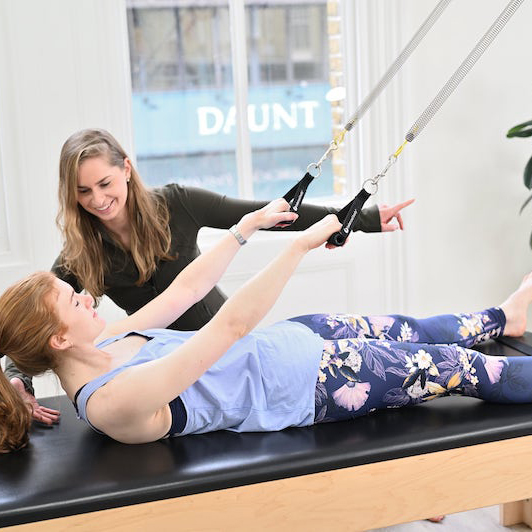 Roll down on the trapeze table a great exercise for Pilates beginners