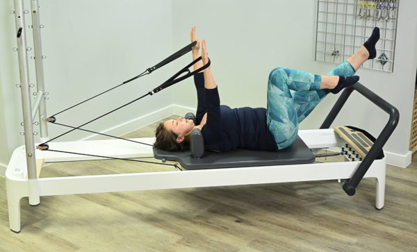 arms in straps Reformer Complete Pilates