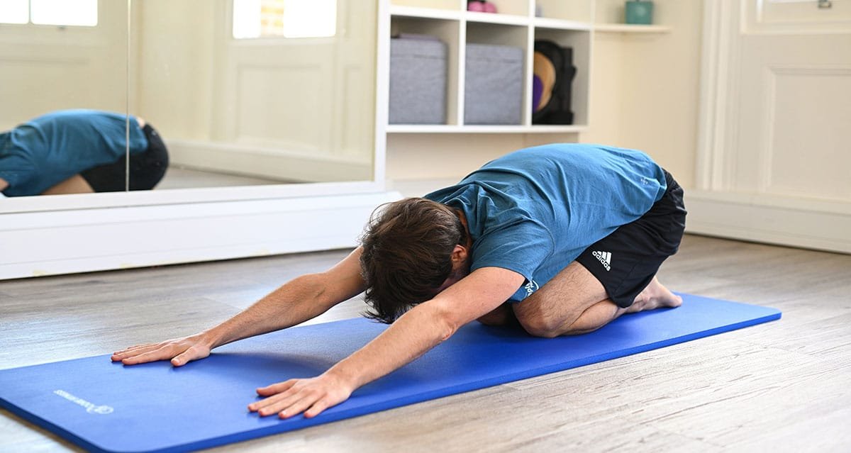 person performing childs pose exercise