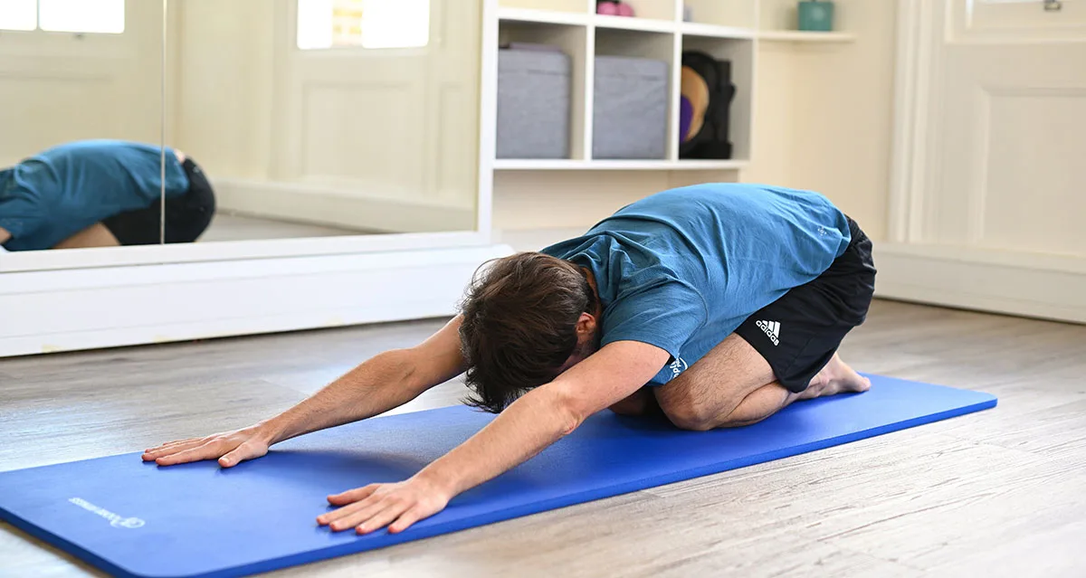person performing childs pose exercise