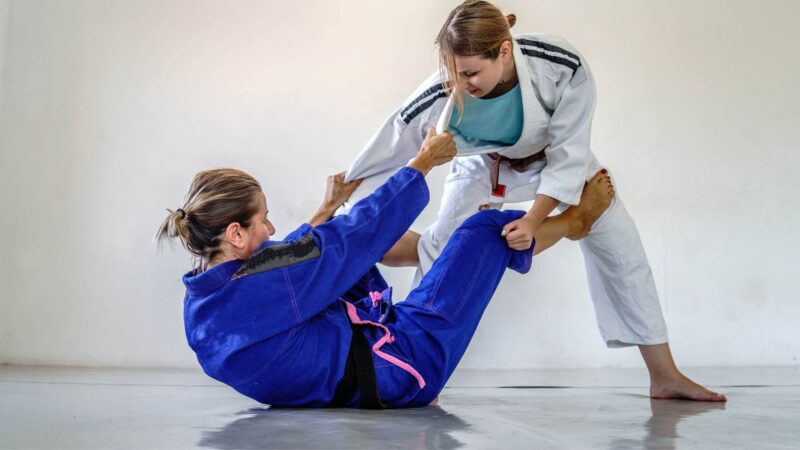 two women playing brazilian jiu jitsu Complete Pilates