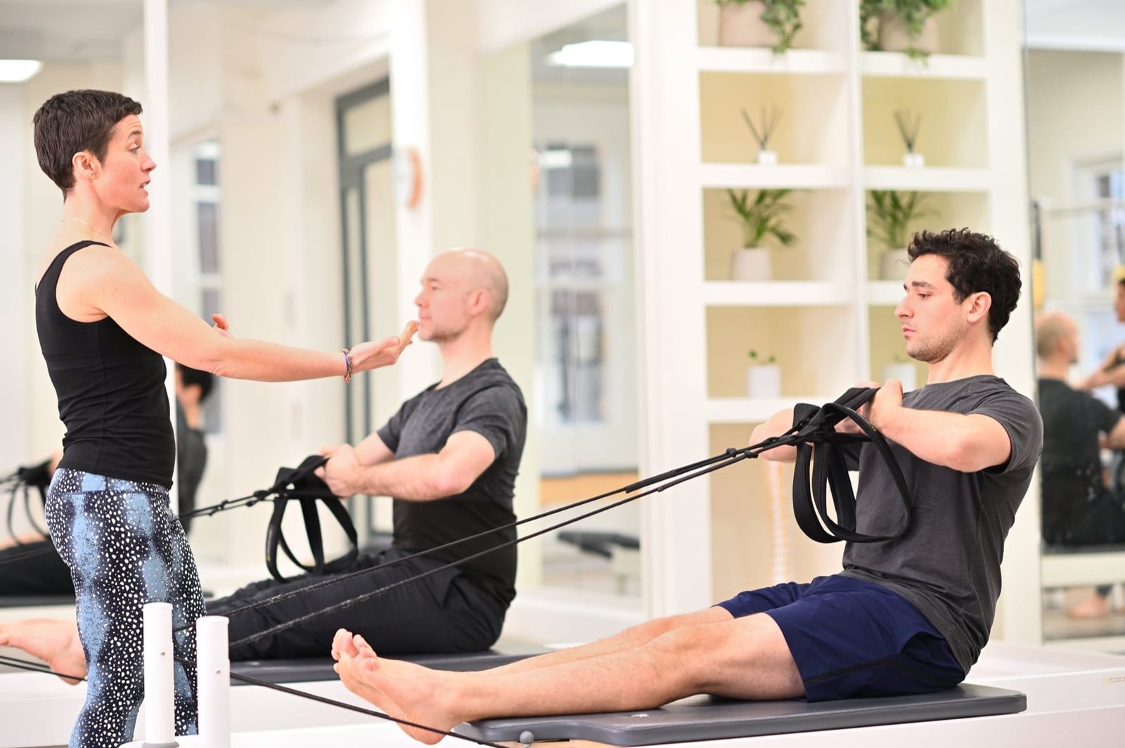men-doing-roll-down-on-the-reformer