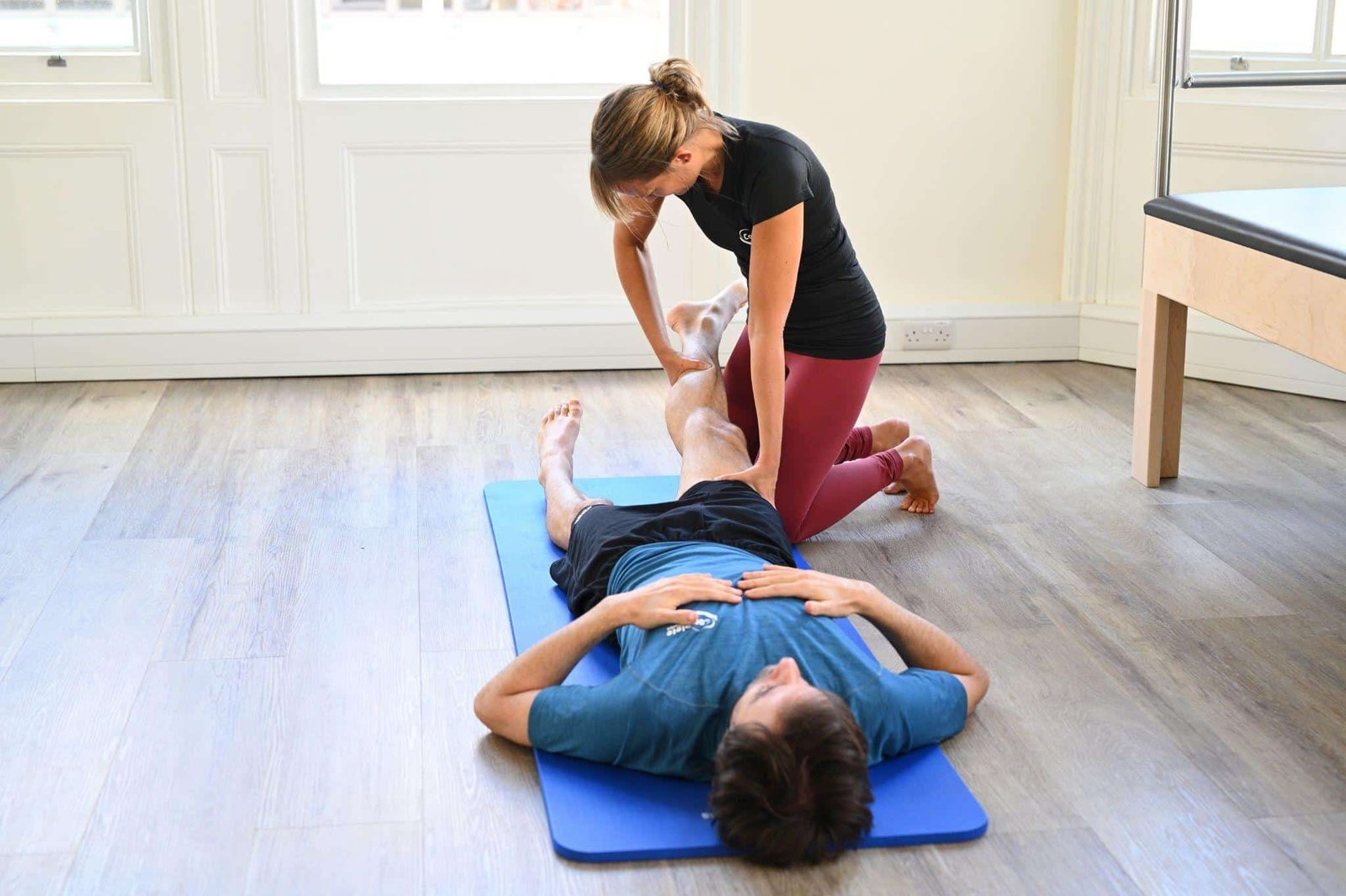 An instructor assessing a client for Pilates