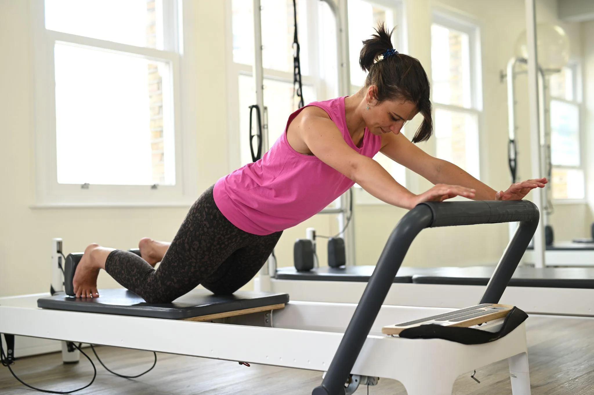 Woman performing an exercise on the Pilates Reformer